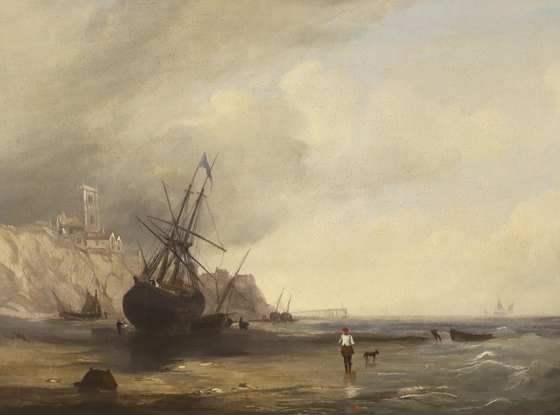 Early 19th century English school, oil on canvas, Beached fishing boats beneath a cliff top church, 39 x 52cm